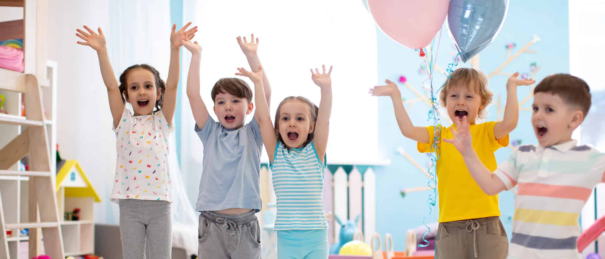 Group of emotional children friends with their hands raised. Kids have fun pastime in day care centre