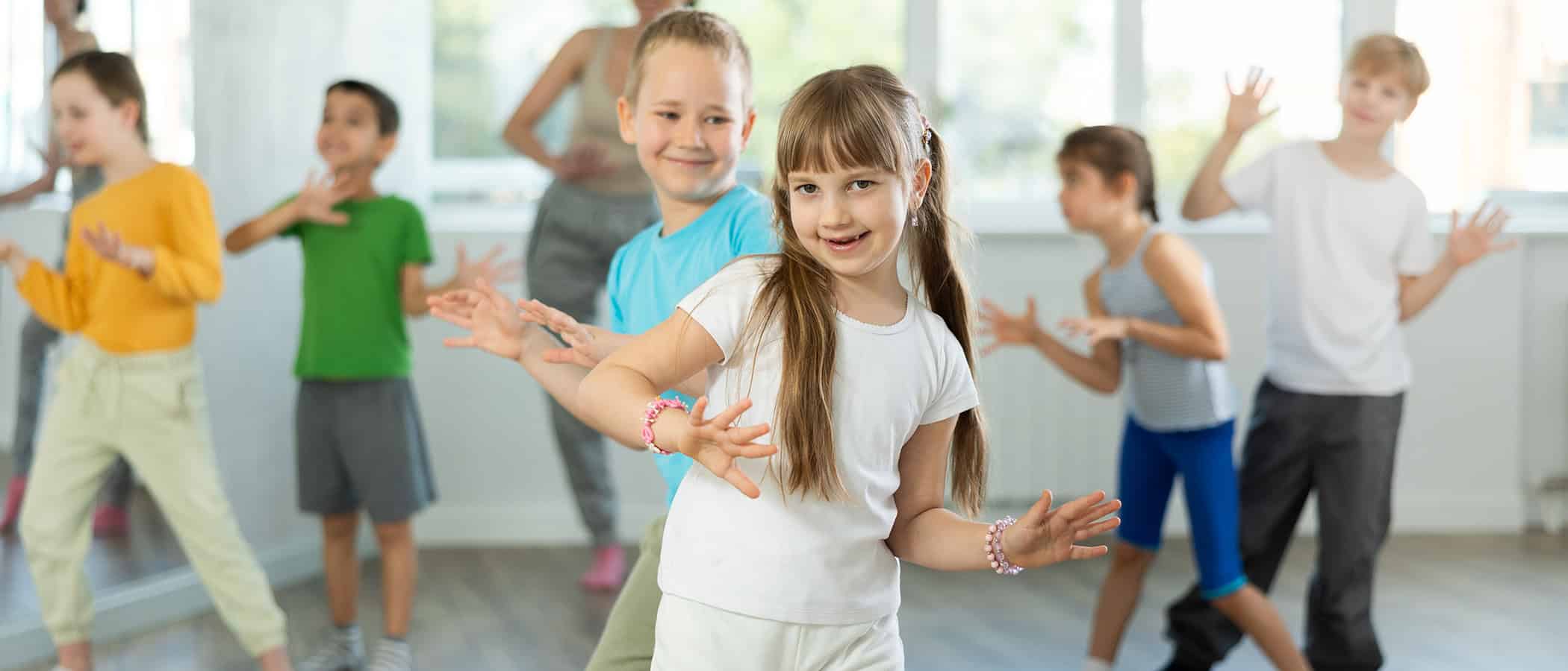 Couple boy and girl dancing fun twist dance in group in studio